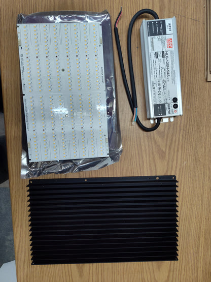 Unassembled HLG 135 Rspec kit showing the LED board, black finned heatsink and Mean Well HLG-120H-54A driver.
